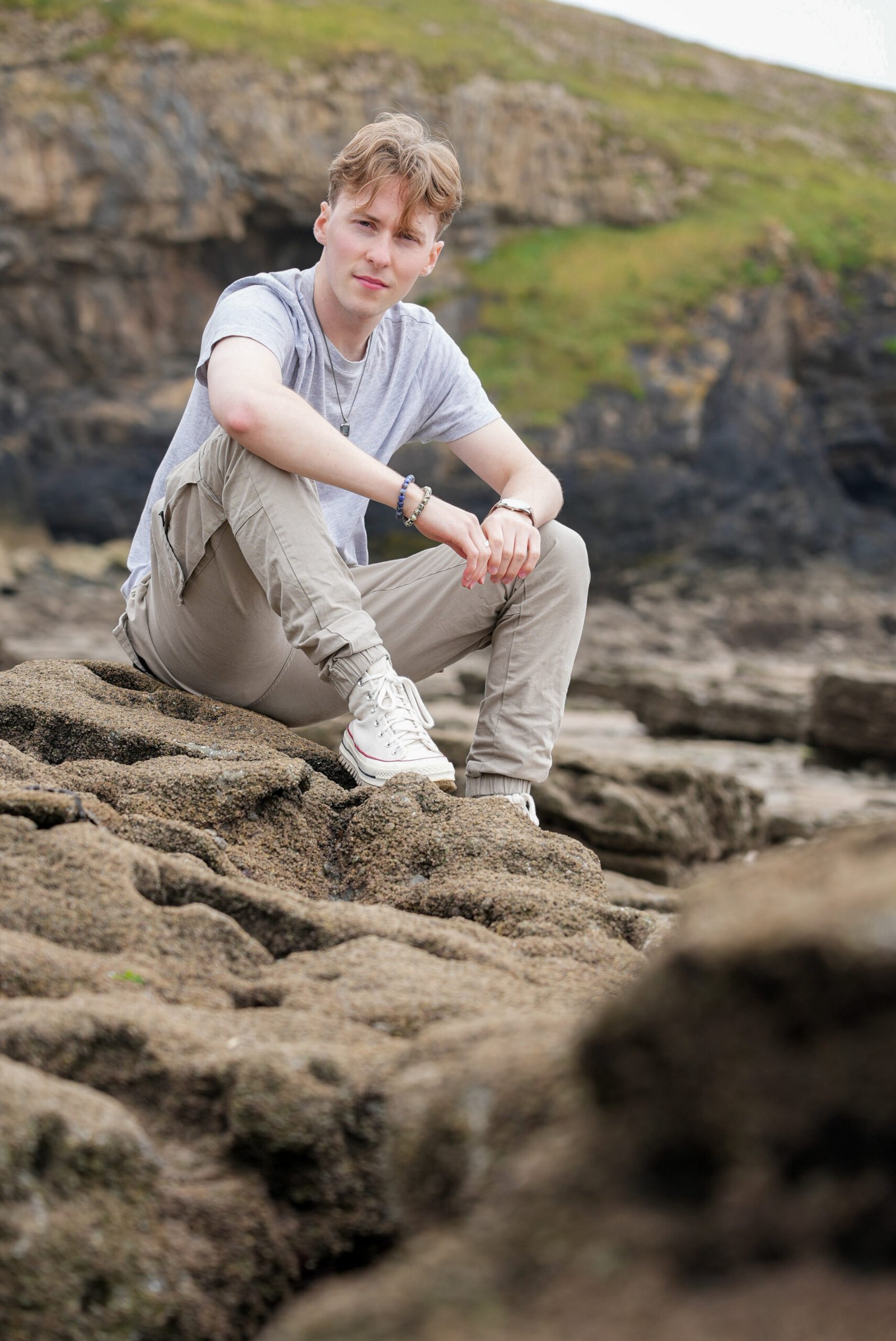 Jamie Moreland Jamie Moreland, sitting on rocks on a Welsh beach